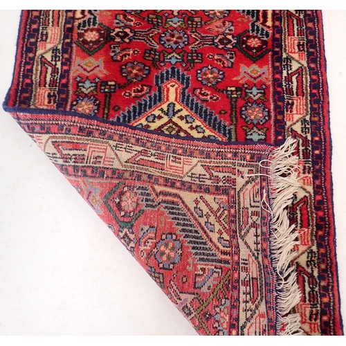1438 - A small Turkish rug with medallion design on a red ground 95x63cm
