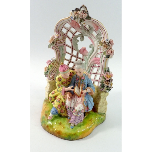 197 - A 19th century Meissen style group of Chinese couple seated reading in floral and scrollwork bower, ... 