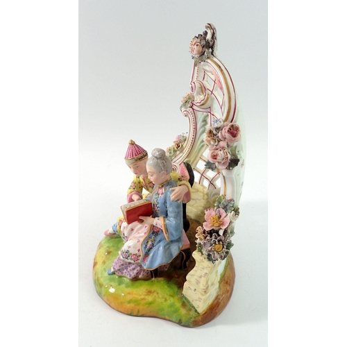 197 - A 19th century Meissen style group of Chinese couple seated reading in floral and scrollwork bower, ... 