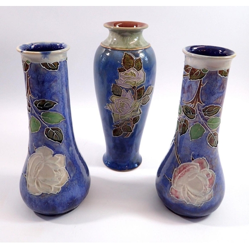 20 - A pair of Doulton stoneware vases and one other decorated roses on a blue ground, 25cm tall
