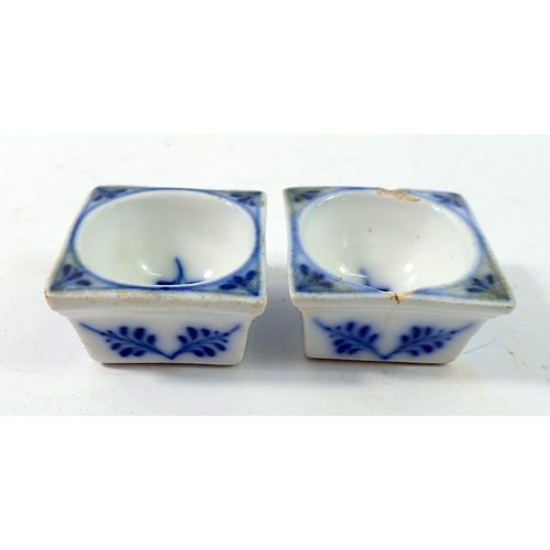 203 - A pair of 19th century blue and white Meissen small square salts painted leaves and flowers, one a/f... 