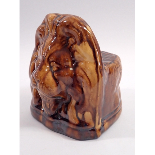 22 - A 19th century brown treacle glazed lion form sash window or furniture rests, 14cm tall