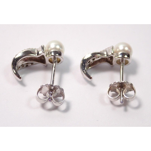448 - A pair of 14 carat white gold earrings set pearl and chip diamonds, 2.5g