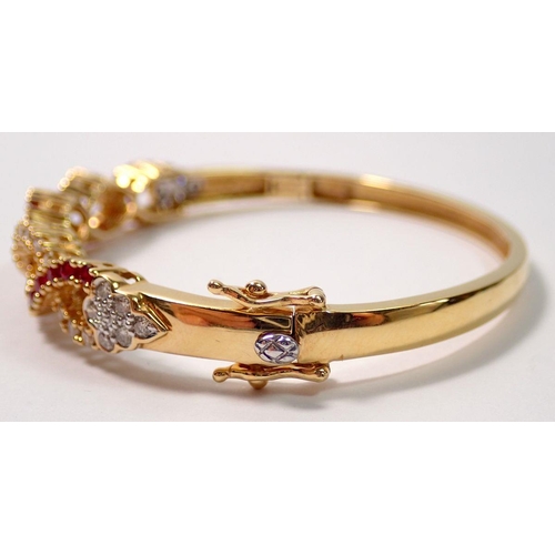 450 - An 18 carat gold hinged bangle with a braided design set diamonds and rubies, 22g