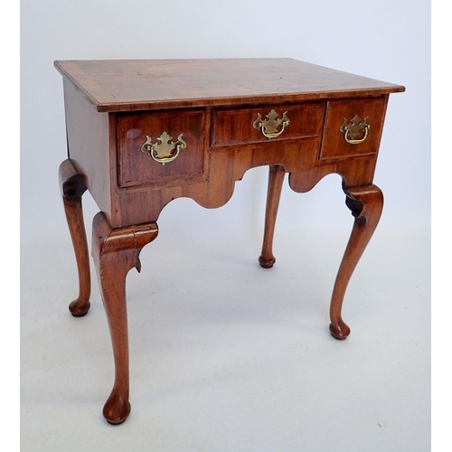 1012 - A George II walnut lowboy with one short and two deep drawers, with shaped frieze and raised on cabr... 