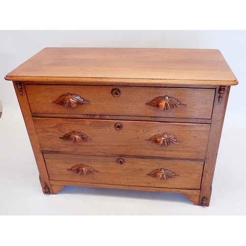 1014 - A continental oak chest of three drawers with carved handles, 102cm