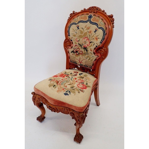 1027 - A Victorian carved walnut side chair with ornate scrollwork carving and woolwork tapestry upholstery