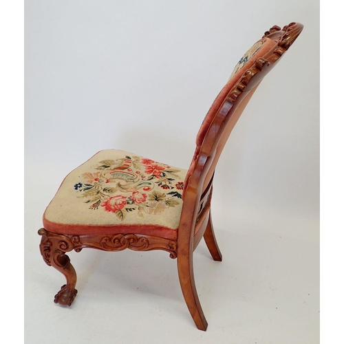 1027 - A Victorian carved walnut side chair with ornate scrollwork carving and woolwork tapestry upholstery