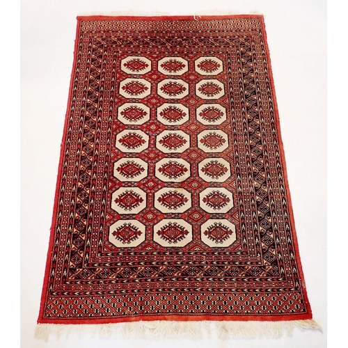 1030 - A Turkoman style rug with three rows of guls on red ground, 185 x 128cm