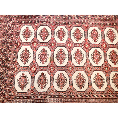 1030 - A Turkoman style rug with three rows of guls on red ground, 185 x 128cm