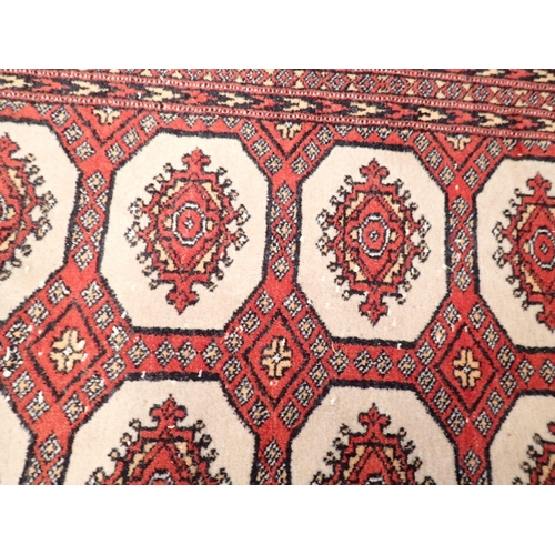 1030 - A Turkoman style rug with three rows of guls on red ground, 185 x 128cm