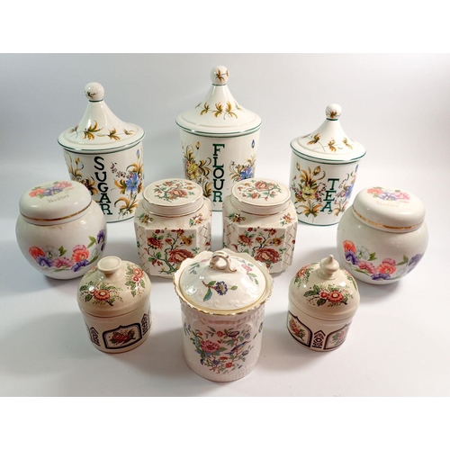 104 - A collection of ten various storage jars with lids including sugar, flour, tea examples, Sadler, Ayn... 