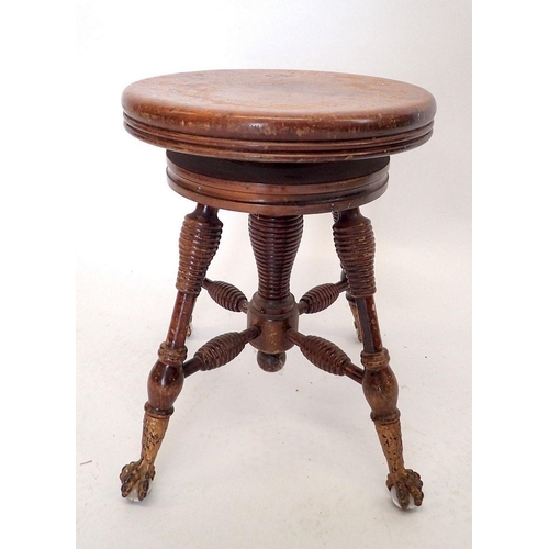 1042 - An American or Canadian mahogany revolving piano stool with gilt metal claw and glass ball feet