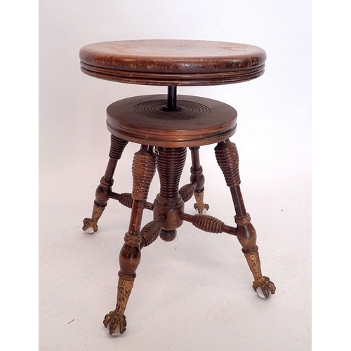 1042 - An American or Canadian mahogany revolving piano stool with gilt metal claw and glass ball feet