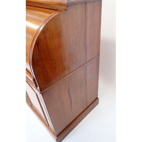 1057 - A Victorian walnut cylinder front desk with satinwood fitted interior all over cupboard on plinth ba... 