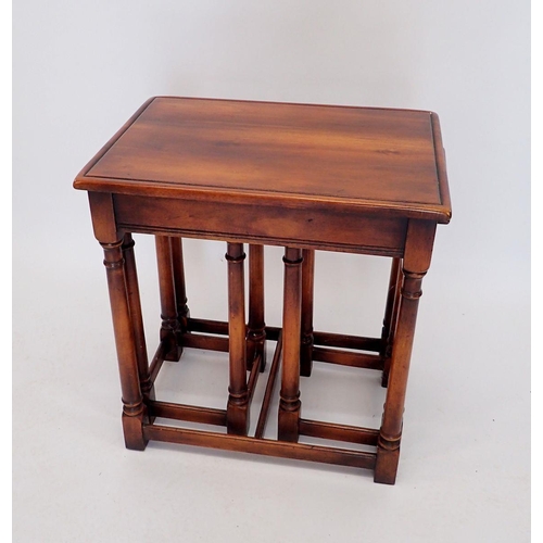 1061 - A nest of three mahogany finish occassional tables on slender supports, 62cm wide