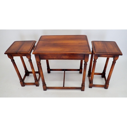 1061 - A nest of three mahogany finish occassional tables on slender supports, 62cm wide