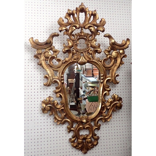 1081 - A 19th century carved Italian gilt wood scrollwork mirror of shield form, 90 x 66cm