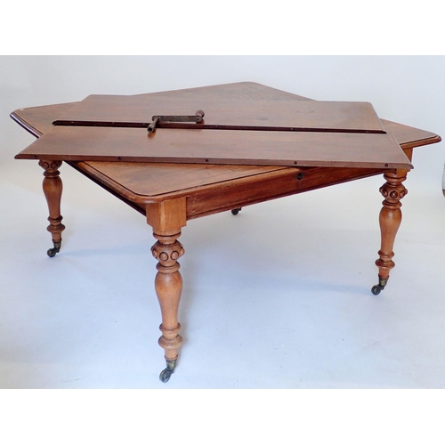 1092 - A Victorian mahogany wind-out dining table with two interleaves, all raised on baluster supports and... 