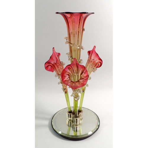 112 - A Victorian cranberry and green glass epergne with central trumpet and three outer trumpets, on a la... 