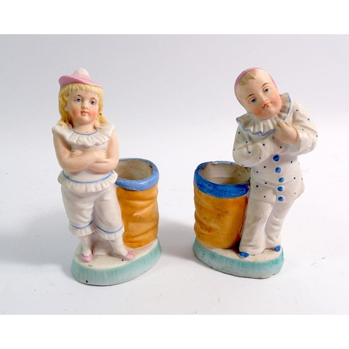 22 - A pair of French bisque spill vases with Poirrot costumed children, 14cm tall