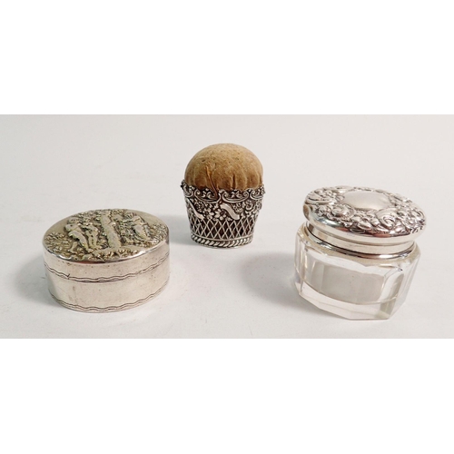 281 - A white metal pin cushion with embossed floral decoration, a silver and glass toiletry pot 3cm tall ... 