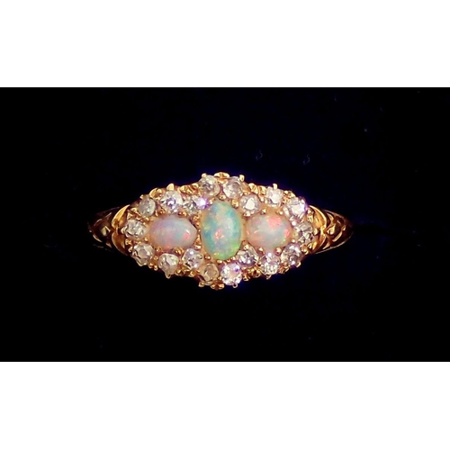 323 - An 18 carat gold ring set three opals within diamond surround, size L-M, 2.5g