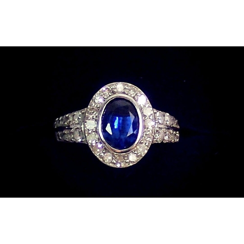 330 - An 18 carat white gold ring set oval cut sapphire within diamond surround and on diamond set shoulde... 