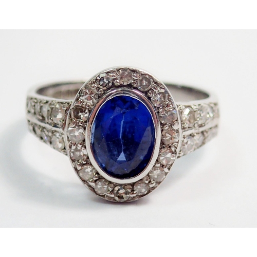 330 - An 18 carat white gold ring set oval cut sapphire within diamond surround and on diamond set shoulde... 