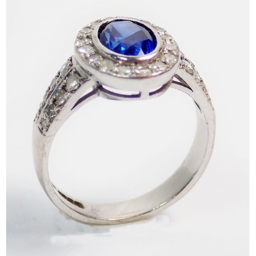 330 - An 18 carat white gold ring set oval cut sapphire within diamond surround and on diamond set shoulde... 