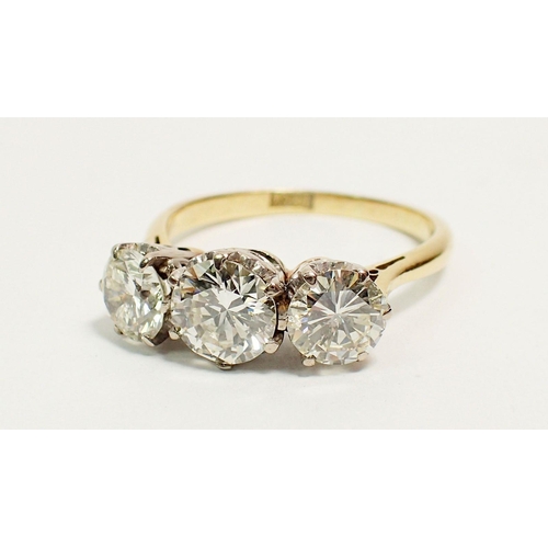 331 - An 18 carat yellow gold three stone diamond ring, size L, 3.5g, centre stone 6mm, side stones 5mm ap... 