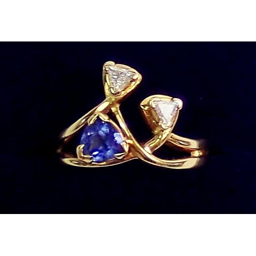 336 - An 18 carat yellow gold ring set asymetrical arrangement of trillion cut tanzanite and two diamonds,... 