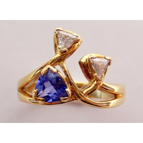 336 - An 18 carat yellow gold ring set asymetrical arrangement of trillion cut tanzanite and two diamonds,... 