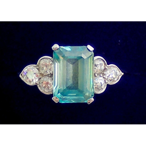 339 - An Art Deco style 18 carat white gold ring set  blue tourmaline flanked by six diamonds, size Q