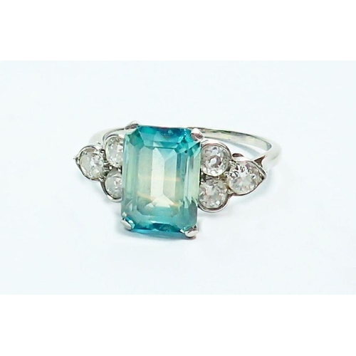 339 - An Art Deco style 18 carat white gold ring set  blue tourmaline flanked by six diamonds, size Q