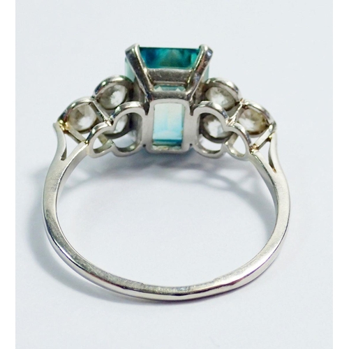 339 - An Art Deco style 18 carat white gold ring set  blue tourmaline flanked by six diamonds, size Q