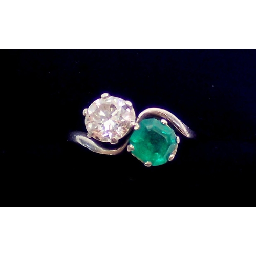 342 - An antique platinum ring crossover set emerald and diamond, size J, 3.6g, the diamond approx. .6cts