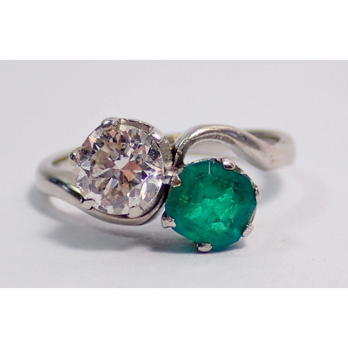 342 - An antique platinum ring crossover set emerald and diamond, size J, 3.6g, the diamond approx. .6cts