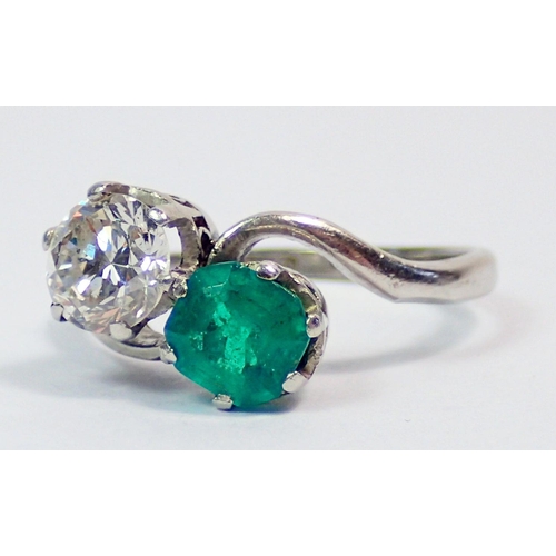 342 - An antique platinum ring crossover set emerald and diamond, size J, 3.6g, the diamond approx. .6cts