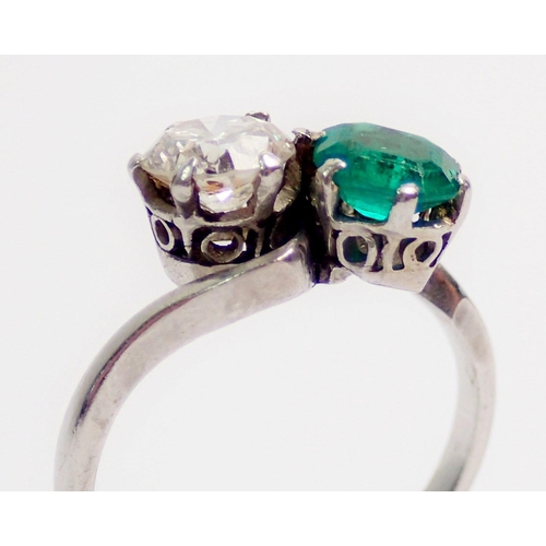 342 - An antique platinum ring crossover set emerald and diamond, size J, 3.6g, the diamond approx. .6cts