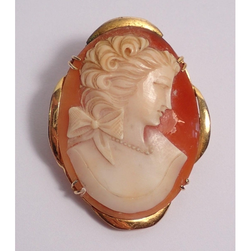 351 - A yellow metal framed cameo brooch carved woman with ribbon to her hair, 9.6g, 4.3 x 3.5cm