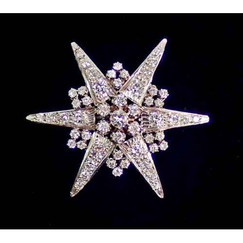 387 - An 18 carat white gold star form brooch set diamonds, 4.5cm diameter, 9.4g