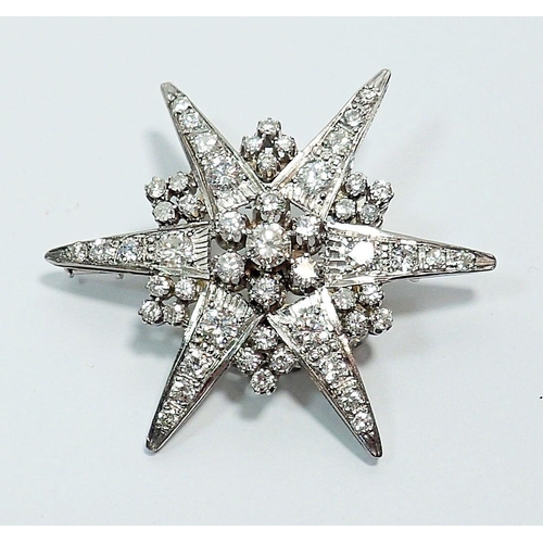 387 - An 18 carat white gold star form brooch set diamonds, 4.5cm diameter, 9.4g