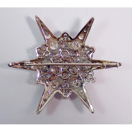 387 - An 18 carat white gold star form brooch set diamonds, 4.5cm diameter, 9.4g