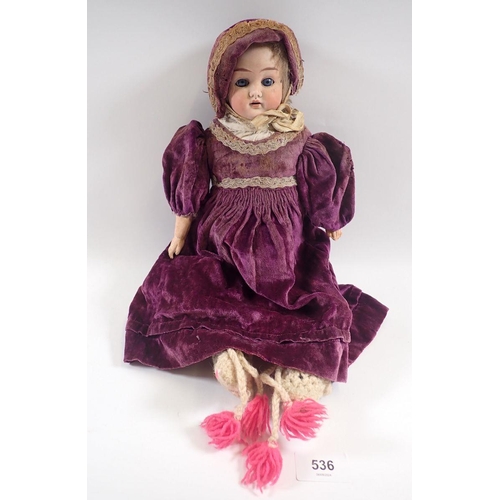 536 - A Victorian bisque head doll with original dress and hat, approx 40cm long, marked Germany