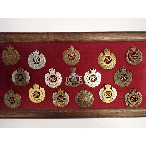 713 - A framed display of sixteen Royal Engineers military cap badges, a framed display of seventeen Welsh... 