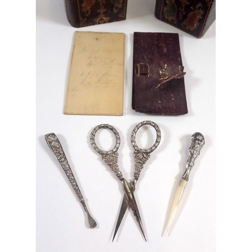 765 - A leather cased etui and part matched contents including silver scissors, snuff spoon and bodger