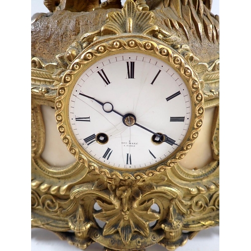 833 - A 19th century French gilt metal mantel clock with figure holding bird surmount, the enameled dial m... 