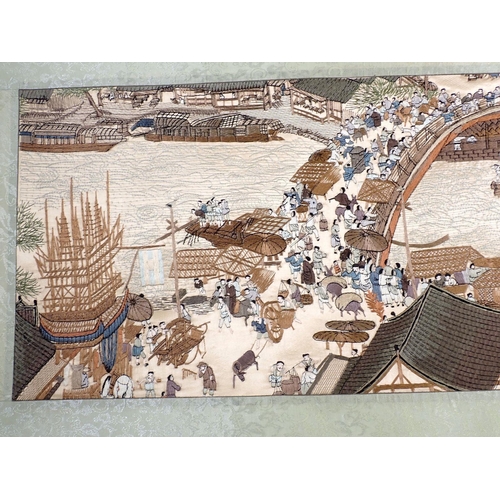 855 - A Chinese Bian style embroidered silk scroll depicting quayside town with bridge and boat, boxed