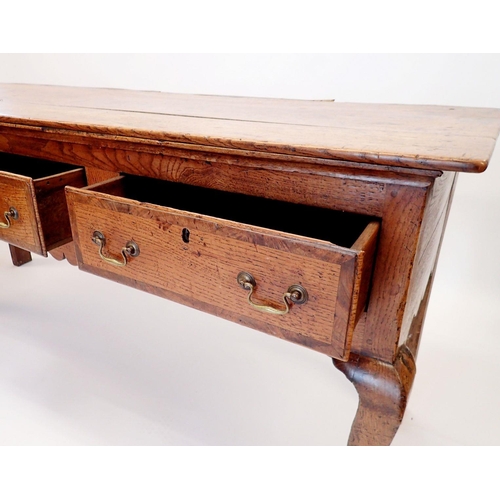 880 - A Georgian oak dresser base with three frieze drawers and brass swan neck handles all raised on cabr... 